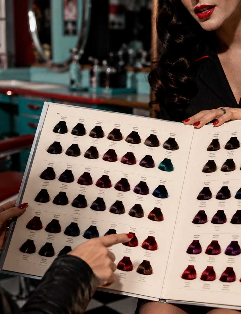 Hair dye swatches displayed in a salon with two people discussing color options.